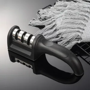 Handheld kitchen knife sharpener detail showing multi-slot metal sharpening wheels and black handle.