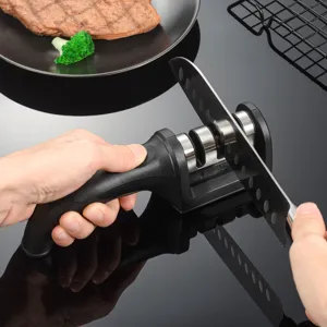 Close-up detail of handheld kitchen knife sharpener in use, showing multi-stage sharpening slots.
