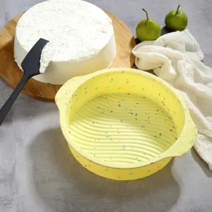 Vista dettagliata dello stampo per torta in silicone giallo con pois colorati, ideale per dolci.