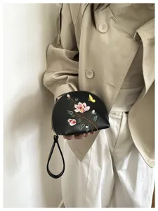 Schwarze, halbkreisförmige bestickte Handgelenktasche mit zartem Blumen- und Schmetterlingsmuster.