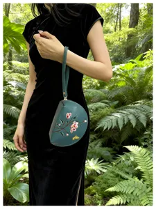 Detailansicht einer ethnischen bestickten Münztasche für Damen im grünen Garten.