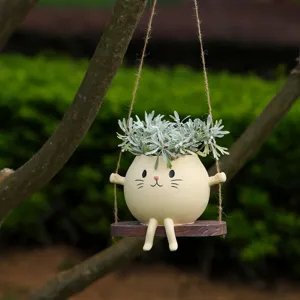 Detailaufnahme des kreativen Tier-Schaukelblumentopfs aus Harz, der im Freien mit Pflanzen hängt.