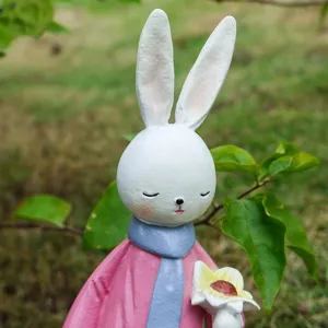 Resin rabbit figurine detail, cute animal ornament holding a flower for home office decor.