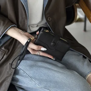 Vue détaillée d'un élégant petit portefeuille noir en cuir avec dragonne pratique.