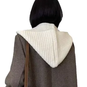 Vista dettagliata del cappuccio lavorato a maglia bianca, perfetto per look invernali.