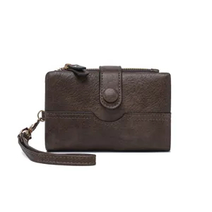 Vue détaillée du portefeuille marron foncé montrant la texture cuir, fentes et dragonne.