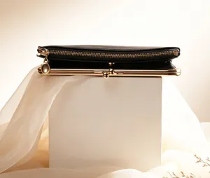 Black retro long wallet detail showcasing metallic frame kiss-lock and zipper compartment.