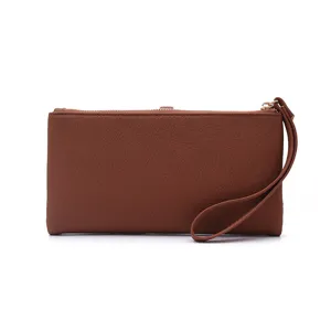 Detail view of the brown women long PU leather wallet showing minimalist texture and wrist strap.