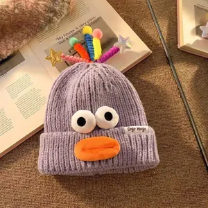 Niedliche lustige Strickmütze mit großen Augen und bunten Sternen, warme Winter-Cartoon-Mütze.
