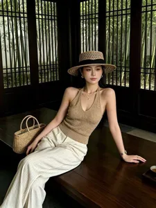 Detailed view of the hollow woven straw hat with a black band, showcasing retro summer style.