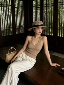 Detail shot of the woven straw hat with black ribbon, showcasing summer seaside beach style.