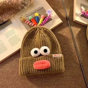 Nahaufnahme der witzigen Strickmütze mit großen Augen und niedlichen bunten Sternen.