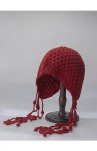Red knitted hollow beanie hat with long tassels and pom poms, perfect for autumn winter.