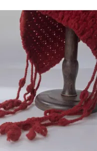 Red hollow knitted winter hat detail, featuring cute tassels and pom-poms for women style.