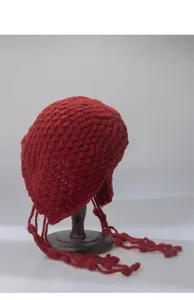 Close-up detail shot of the red knitted hollow tassel beanie cap, showing fine texture.
