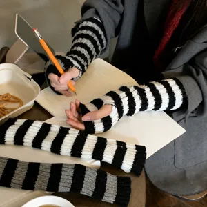 Detailed view of women's black and white striped knit fingerless arm warmers for winter.
