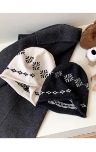 Détail des bonnets d'hiver en tricot ample avec motifs de flocons de neige contrastés.