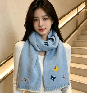 Detail view of women's warm knitted scarf featuring cute butterfly embroidery and cozy design.