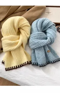 Thick knitted winter scarf detail view, cozy wool neck warmer in yellow and blue colors for cold weather.
