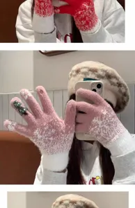 Detail view of winter women's touchscreen knit gloves with cute Christmas tree patterns.