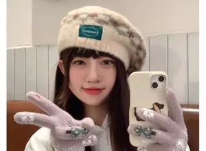 Detail view of cute winter knit gloves with Christmas tree pattern and matching beret hat.
