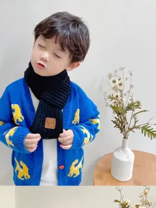 Detailed shot of cute kids knitted scarf featuring warm woolen material and stylish patch.