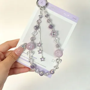 Detail view of a purple crystal beaded phone strap with cute star tassels and keychain charm.