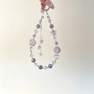 Detail view of the purple crystal beaded phone charm with delicate double layers and cute star tassels.