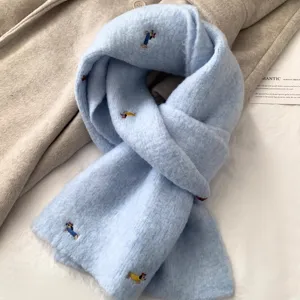 Cute dachshund embroidered light blue knitted scarf detail for autumn and winter warmth.