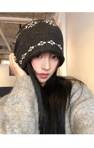 Vue détaillée d'un bonnet en tricot gris foncé Fair Isle avec des motifs de flocons, hiver.