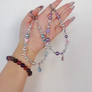 Detailed view of handmade beaded phone charm wrist strap with cute star and crystal pendants.