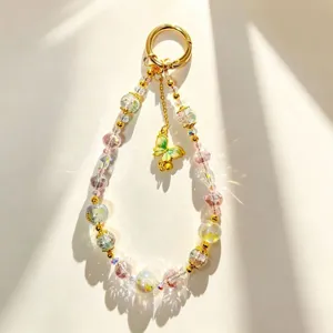 Detailed shot of luxury crystal beaded phone charm with gold butterfly pendant and sparkle beads.