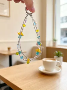 Handmade beaded double chain phone charm with colorful glass mushrooms and crystal beads detail.