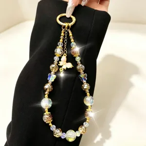 Close-up of luxury beaded phone charm featuring crystal popcorn beads and gold butterfly.