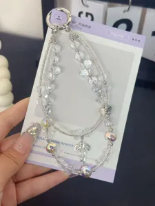Detailansicht der doppelten Kristall Handy-Kette mit Schleife und schillernden Perlen.