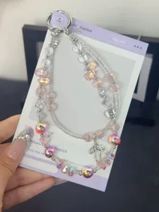 Doppelschichtiges Kristall Handy-Charm mit schillernden Perlen und süßem Schleifenanhänger.