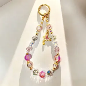 Close-up detail of luxury beaded phone charm with pink crystal beads and alloy butterfly pendant.