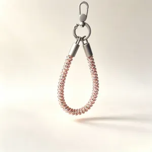 Detail view of rose gold telephone wire phone wrist lanyard close up clasp texture.