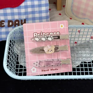 Ensemble de pinces à cheveux mignonnes ours et pattes sur carte rose vue détaillée.