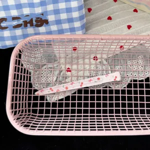 Detailed view of a cute pink long hair clip with lovely cartoon print inside a pink basket.