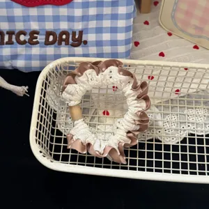 Detail view of brown plaid lace hair scrunchie, sweet style pony tail hair tie accessory.