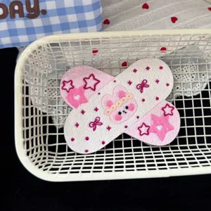 Vista dettagliata forcina orsetto rosa anime carino, forma cerotto ricamata stile dolce grazioso accessorio.