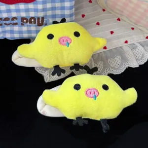 Primo piano di mollette per capelli a papera in peluche giallo, stile dolce e morbido.