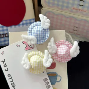 Close-up detail of cute plaid hat hair clips with small angel wings, sweet kawaii accessory.