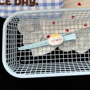 Close-up shot of a cute blue hairpin with a playful food toy cartoon character decoration.