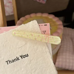 Nahaufnahme der süßen Gitter Blumen Haarspange, mit süßer Schleife und Eis-klarer Textur.