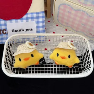 Detailed shot of cute plush little yellow duck hair clips with straw hat design, sweet style.