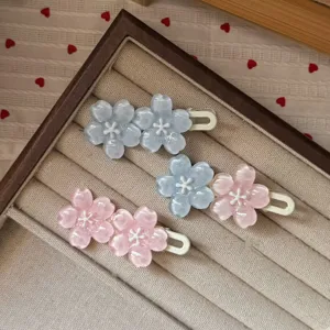Vista dettagliata di forcine fiori di ciliegio in resina, accessori per capelli estetici rosa blu.