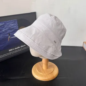 Vista detallada de sombrero de pescador japonés gris claro con costuras en soporte de madera.