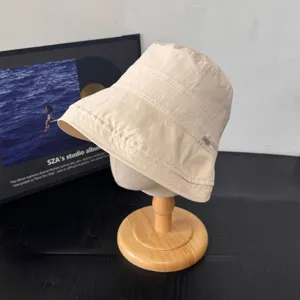 Vista detallada de un sombrero de pescador beige de estilo japonés con ala enrollada.